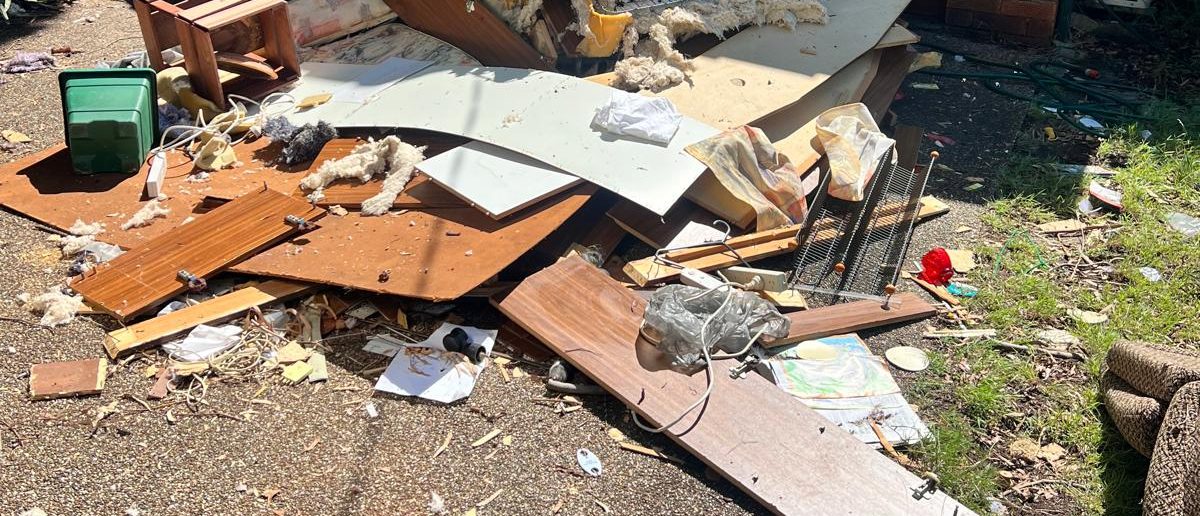 Renovation rubbish piled beside a brick house